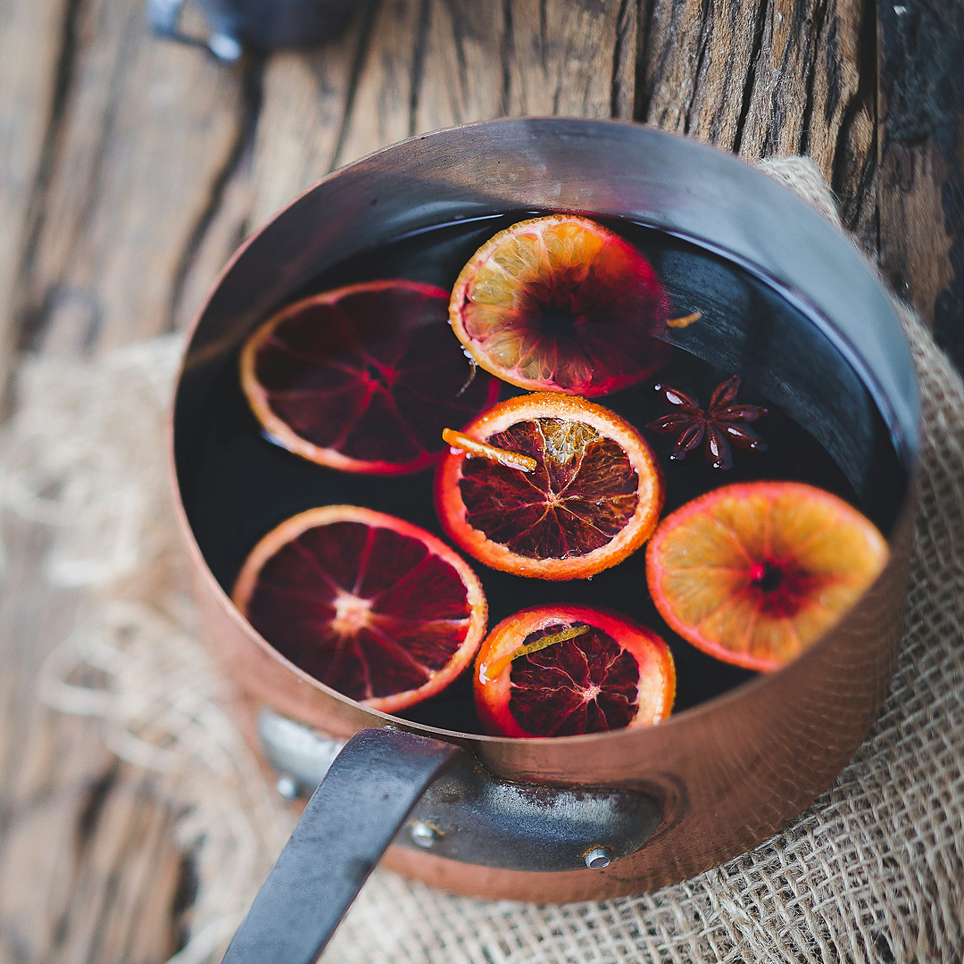 Non-alcoholic mulled wine in a copper pot with orange slices and star anise